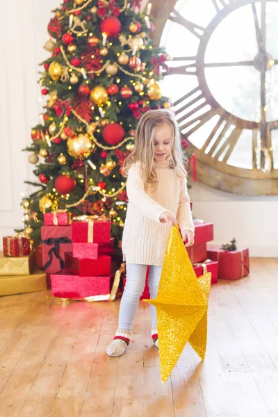 可爱的小女孩与圣诞树在背景上的圣诞明星 — 图库照片
