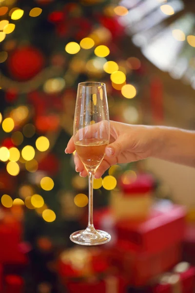クリスマス ツリーの背景色のシャンパン グラスを持つ若い女性 クローズ アップ — ストック写真