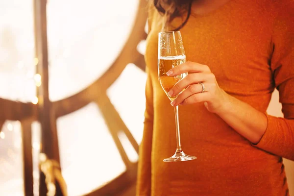 年轻漂亮的女人与玻璃香槟在光的背景 — 图库照片