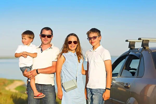 海の背景が付いている車で 人の子供を持つ家族を笑ってハッピー 車でビーチで二人の子供を持つ笑顔家族の肖像画 休日および旅行のコンセプト — ストック写真