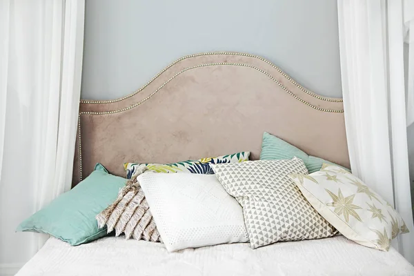 Modern bedroom with green and golden pillows