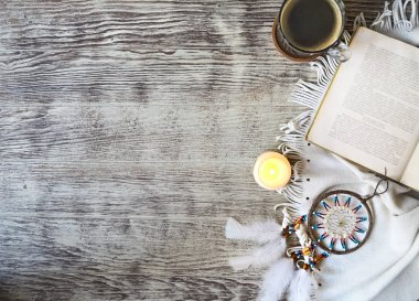 Kitap, mum, Rüya yakalayıcı ahşap masa üzerinde kalarak kahve fincan. Boho stili