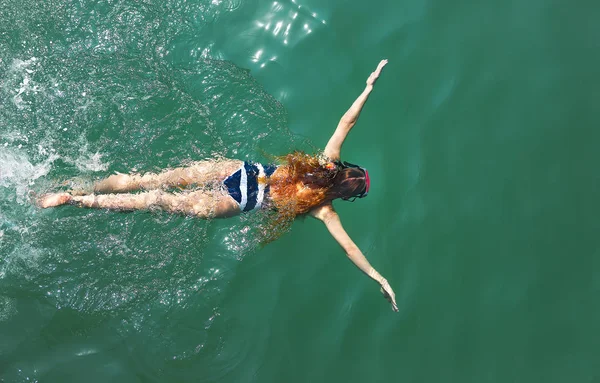 바다에서 마스크를 흰색과 파란색 수영복에 여자의 하향식 — 스톡 사진