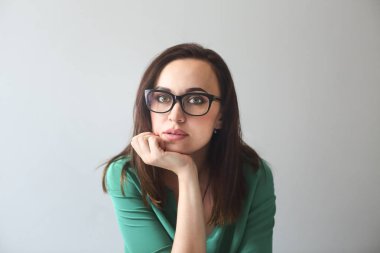 Katta oturan ve kameraya gülümseyen genç kadın 