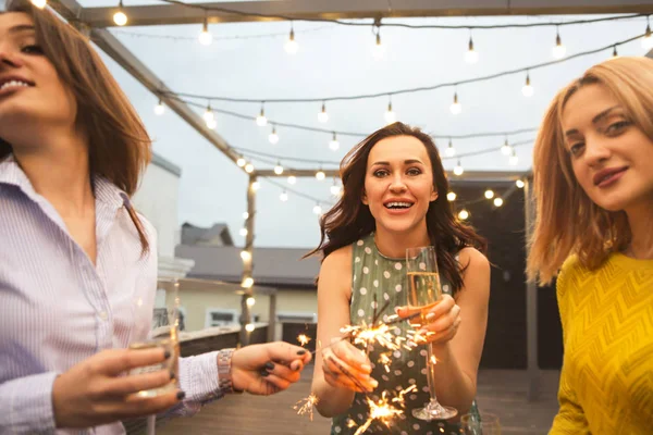 スパーク リング ワインとベンガル火パーティで楽しい時を過すとフルートとのパーティーの女の子のグループ — ストック写真