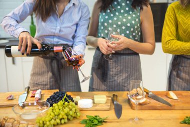 Birlikte bir yemek hazırlama ve mutfakta kırmızı şarap içme neşeli arkadaşlar 