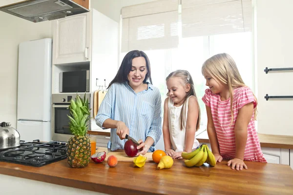 新鮮なフルーツ サラダを準備する台所で母は彼らの美しい女の子 — ストック写真