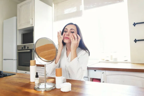 Linda Mujer Sonriente Aplicando Crema Facial Con Bata Blanca Por — Foto de Stock