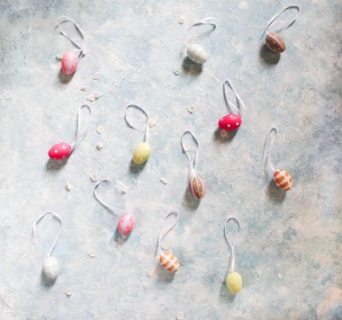 Paskalya yumurtaları ve bahar çiçekleriyle paskalya arkaplanı. Kopyalama alanı olan üst görünüm