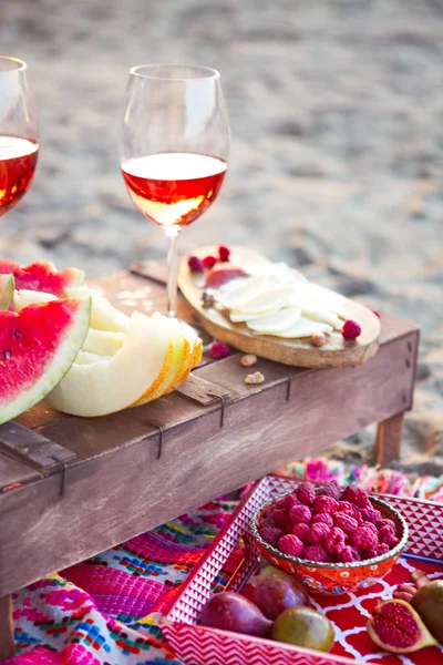 Outdoor picnic  with rose wine, fruits meat and cheese