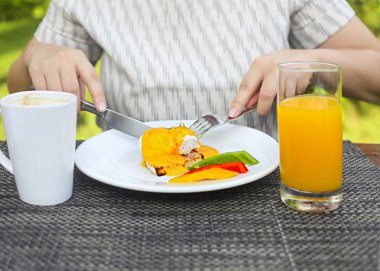 Kadın yemek yumurta Benedict bir kafeterya masada resim kırpılmış 