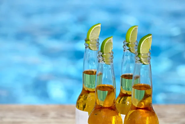 Θέα Closeup Μπουκάλια Μπύρας Και Φέτες Λάιμ Δίπλα Στην Πισίνα — Φωτογραφία Αρχείου