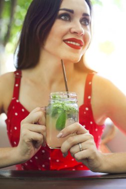 Bir mason kavanoza bir mojito ile onun elinde tutan genç esmer kadın. Yaz içki kavramı