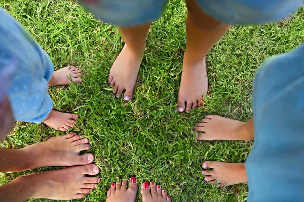 夏の日の屋外の時間を費やして幸せな若い家族 草の上のフィート トップ ビュー — ストック写真