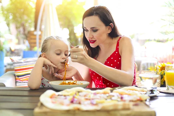 愉快的母亲和女儿一起在餐厅吃意大利面博洛尼亚 — 图库照片