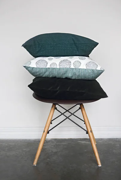 Green pillows on the chair on light background