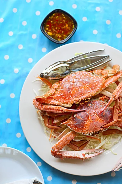 两只新鲜煮熟的螃蟹在白色盘子上用白色卷心菜服务在老式波尔卡圆点背景 — 图库照片