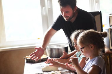 Baba ve onun iki küçük yardımcıları. Çocuk orada baba ile ev yapımı ekmek pişirme