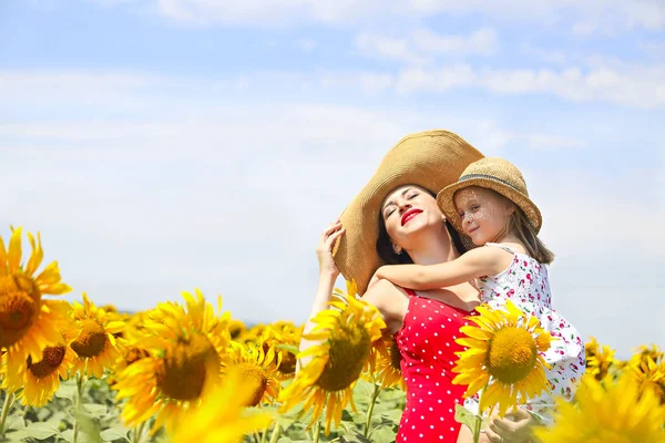 幸せな母親と彼女の小さな娘のひまわり畑で — ストック写真