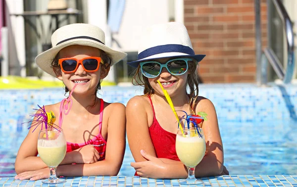 在夏季泳池派对上 两个戴着太阳镜 头戴鸡尾酒戴帽子的快乐小女孩 — 图库照片