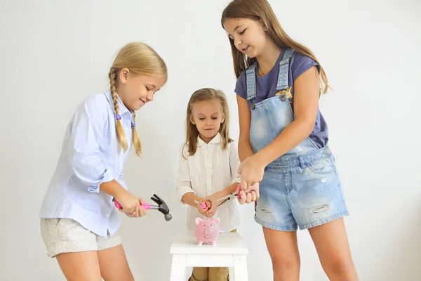 孩子用螺丝刀 钳子和锤子由粉红色猪存钱罐在白色背景 — 图库照片