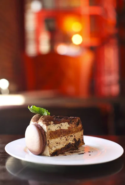 Stück Dunkle Schokoladenkuchen Mit Macaron Und Minze Auf Weißem Teller — Stockfoto