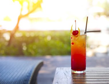Parlak tekila sunrise kokteyl bardak havuzun yanında. Tropik adada lüks resort