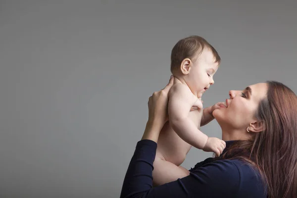 Sevgi Dolu Bir Anne Bebek Kızı Gri Arka Plan Üzerinde — Stok fotoğraf