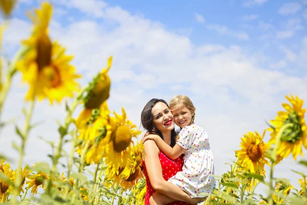 幸せな母親と彼女の小さな娘のひまわり畑で — ストック写真