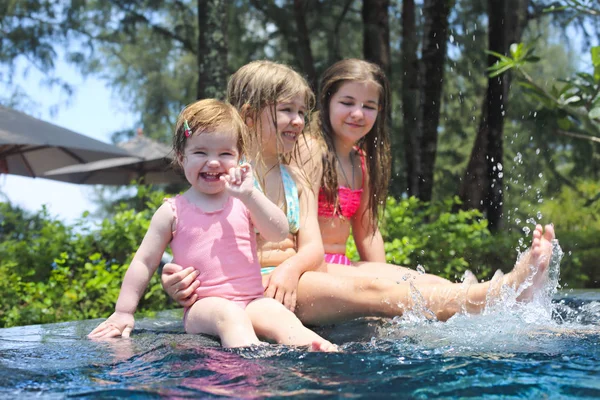 Drie schattige meisjes spelen in zwembad — Stockfoto