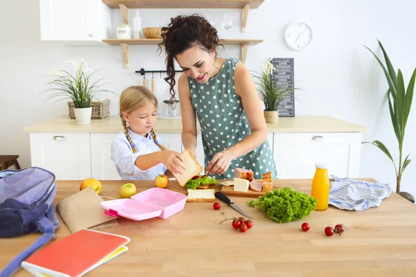 Bella bruna madre e sua figlia imballaggio pranzo sano — Foto Stock