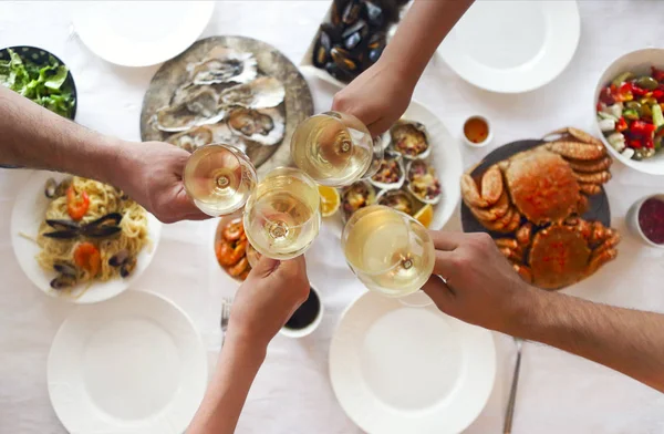 People fine dining seafood and white wine on the table