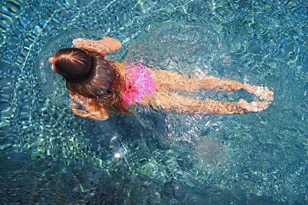 Bambina che nuota nella piscina all'aperto — Foto Stock