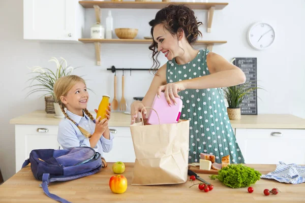 Bella bruna madre e sua figlia imballaggio pranzo sano — Foto Stock