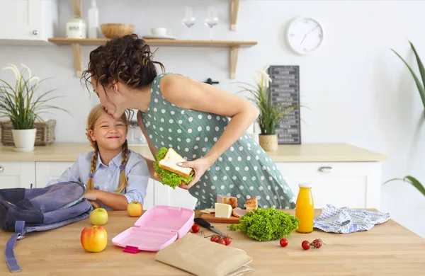 Bella bruna madre e sua figlia imballaggio pranzo sano — Foto Stock