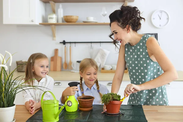 Hermosas mujeres jóvenes con dos hijas lindas plantando fl — Foto de Stock