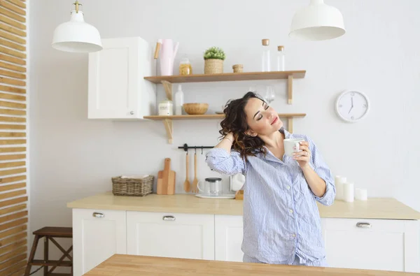 Junge hübsche Frau trinkt ihren Morgenkaffee in der Küche — Stockfoto