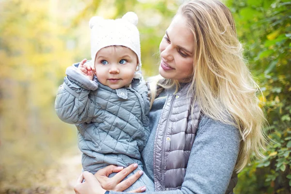 Madre y su hija pequeña juegan abrazos en otoño caminar en n — Foto de Stock