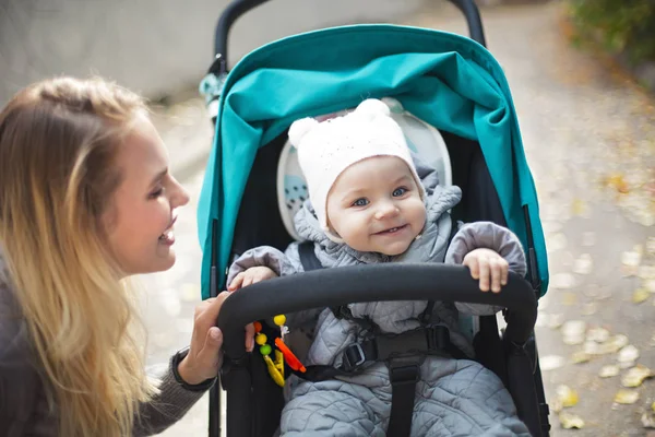 年轻的金发女人带着婴儿车去公园散步 — 图库照片