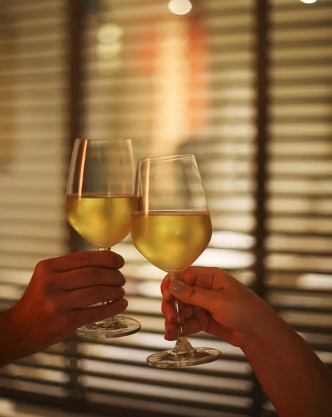 Casal jovem com dois copos de vinho branco na cama no borrão — Fotografia de Stock