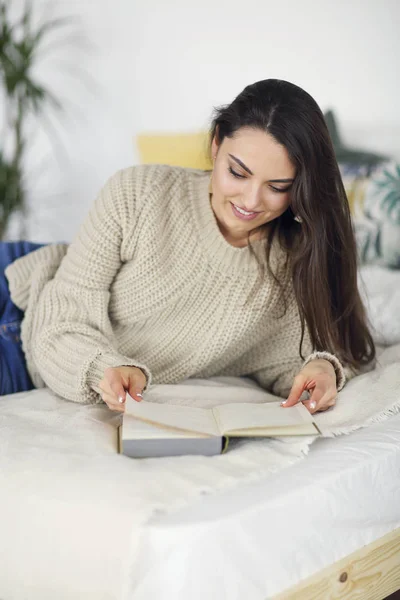 Jeune femme brune heureuse avec livre — Photo