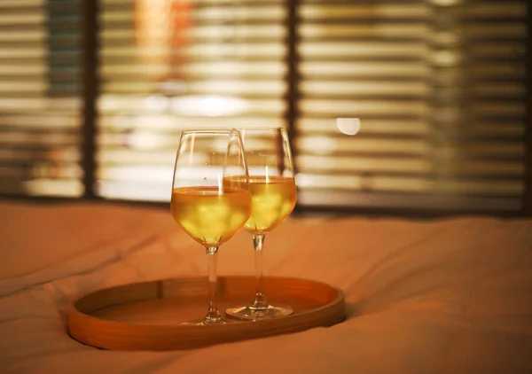 Dwie szklanki białego wina w łóżku na niewyraźne tło — Zdjęcie stockowe