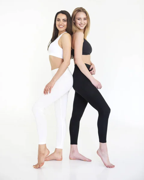 Two sport girls blond in black and brunette in white isolated on — Stock Photo, Image