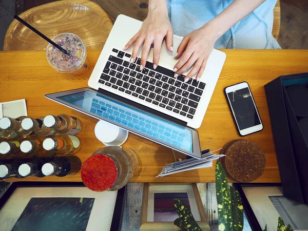 Beautiful mixed race woman sitting in a coffee shop using her la — Stock Photo, Image