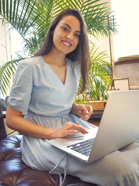 Beautiful mixed race woman sitting in a coffee shop using her la la — стоковое фото