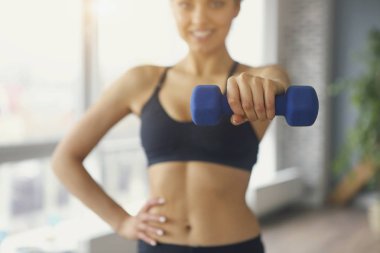 Spor salonunda spor yapan genç bir bayan spor yapıyor.