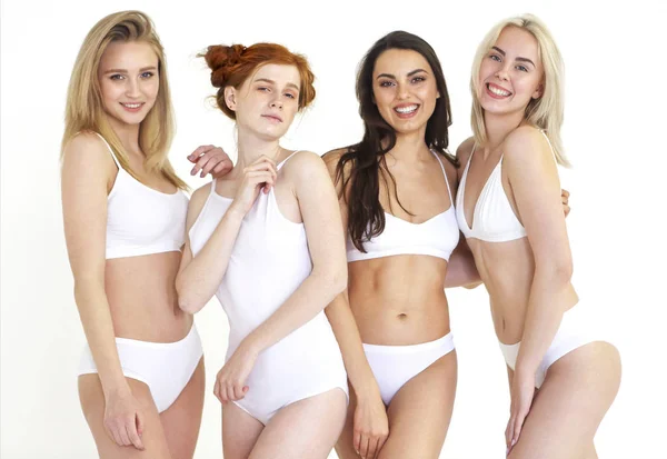 Fröhliche junge multiethnische Frauen in weißen Dessous zusammen — Stockfoto