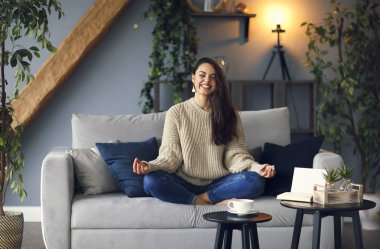 Cute smiling woman is learing yoga at home clipart