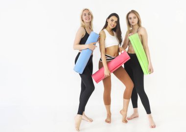 Yoga paspaslar kapalı ayakta tutan sportif mutlu kadın grubu
