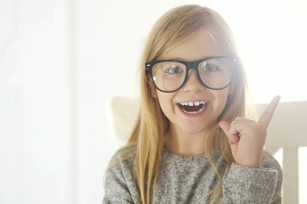 Mosolygó aranyos kislány fekete szemüveges fehér háttérben — Stock Fotó